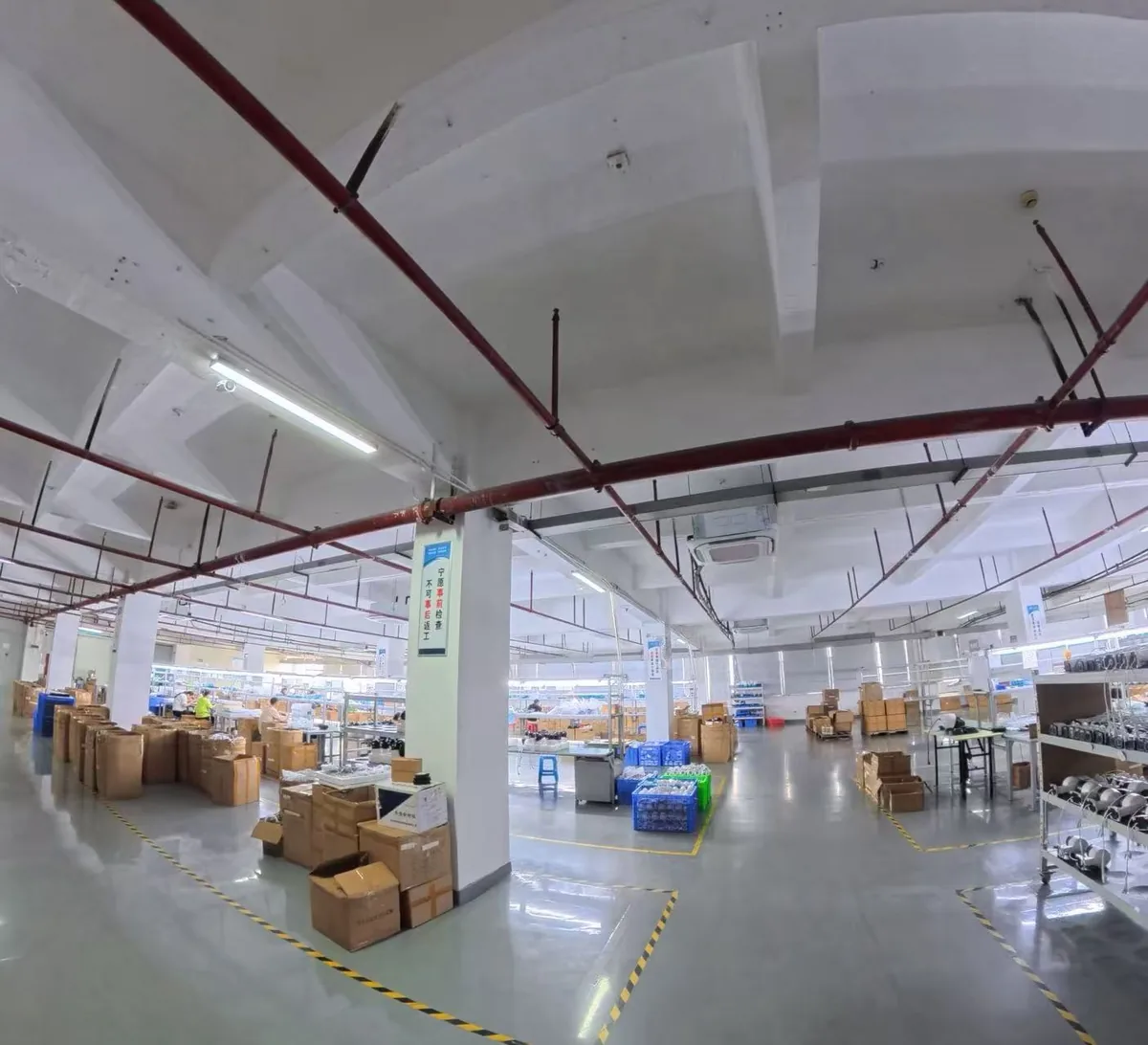Wide view of the AtBingo production hall with assembly benches and a packing area